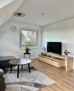 ein Wohnzimmer mit einem Flachbild-TV und einem Couchtisch in der Unterkunft Wundtgasse 29 in Wien