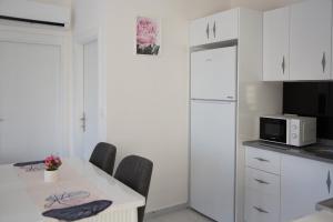 kuchnia ze stołem z krzesłami i kuchenką mikrofalową w obiekcie Art life apartments (PEONY) w mieście Alanya