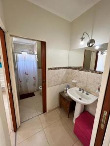 y baño con lavabo y ducha. en JUANA II en Villa Elisa