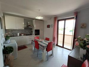 a kitchen with a table and red chairs in a room at Villa Rosetta in Villaggio Mosè +20 photos