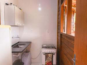 a small kitchen with a stove and a sink at Chalés Requinte em Pedra Azul in Pedra Azul