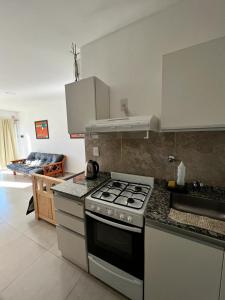 una cocina con estufa y encimera en Antonia, en Villa Elisa