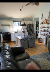 ein Wohnzimmer mit einem Sofa und einer Küche in der Unterkunft Seaside chalet,Aboiteau beach cottage rentals,cap pele in Cap-Pele