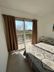 Un dormitorio con una cama y una ventana grande. en Antonia, en Villa Elisa