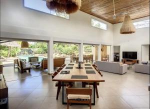 a large living room with a table and chairs at Villa with pool and tropical garden Madagascar in Marokindro