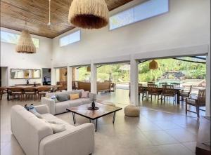 a living room with white couches and a table at Villa with pool and tropical garden Madagascar in Marokindro