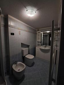 a bathroom with a toilet and a bidet and a sink at Maison Chez Bollon in Aosta