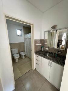 a bathroom with a toilet and a sink and a mirror at Antonia in Villa Elisa +50 photos