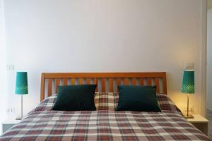 - une chambre avec un lit et 2 oreillers verts dans l'établissement Casa Ariosto, appartamento moderno e luminoso, à Carpi