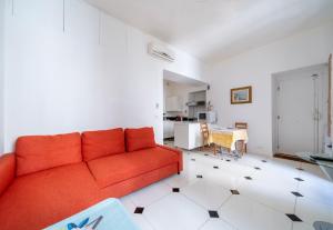 a living room with a red couch and a kitchen at Appartement Claudia - Central - Very close to Sea - Calm - AC in Nice