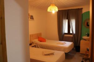 a hotel room with two beds and a bathroom at El Refugio Valdelinares Gastro Hostal in Valdelinares