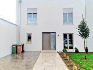 ein weißes Haus mit einer Tür und einem Baum in der Unterkunft Spacious&Luxurious 5 bedrooms House 