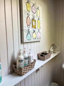 a bathroom shelf with bottles and baskets on it at Stirling House in Kelowna