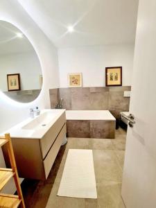 uma casa de banho com um lavatório, uma banheira e um espelho. em Spacious&Luxurious 5 bedrooms House 