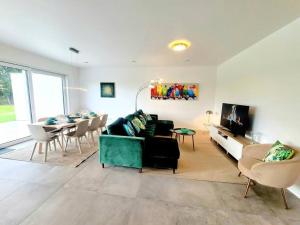 een woonkamer met een groene bank en een tafel bij Spacious&Luxurious 5 bedrooms House 