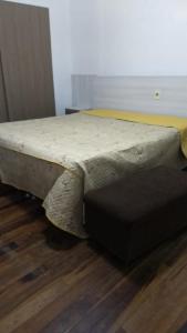 a bed sitting on top of a wooden floor at CASA ACONCHEGANTE PROXIMO VILA GERMÂNICA in Blumenau