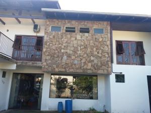 a building with windows and a stone wall at CASA ACONCHEGANTE PROXIMO VILA GERMÂNICA in Blumenau