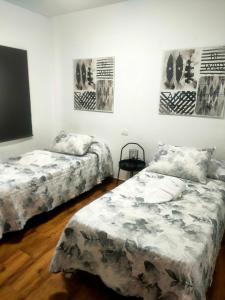 two beds in a room with posters on the wall at Apartamento Almogrote in San Isidro