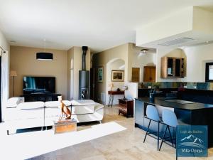 a living room and kitchen with a couch and a table at LOGIS DES ROCHES - 2 VILLAS VUE EXCEPTIONNELLE - Le Petit Chevalet, Le Grand Sabouillon in Buis-les-Baronnies