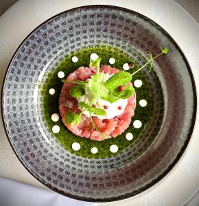 un plato con un trozo de comida con verduras. en Hôtel-Restaurant L'Auberge en Spa