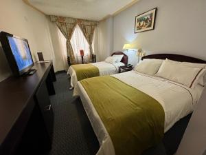 Habitación de hotel con 2 camas y TV de pantalla plana. en Hotel Los Andes, en Ipiales