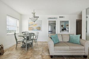 a living room with a couch and a table at Sunrise at the Beach - 2BR Apt with Scenic Views in Satellite Beach