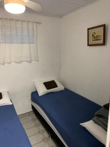 a bedroom with two beds and a window at Casa em Arraial do Cabo na praia grande in Arraial do Cabo