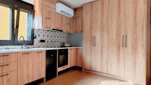 cocina con armarios de madera y lavavajillas negro en Doce Dioces , By IdealStay Experience, en Ligaria