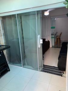 a glass door in a room with a living room at Casa em Arraial do Cabo na praia grande in Arraial do Cabo