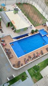 uma vista sobre uma grande piscina com cadeiras em Apartamento Aconchegante em Balneário Piçarras em Piçarras