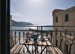 einen Tisch auf einem Balkon mit Meerblick in der Unterkunft Devalù casa del mare in Cefalú