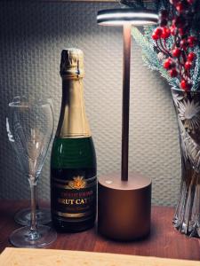 a bottle of champagne on a table next to a wine glass at La Chambre des Trois Églises in Riquewihr