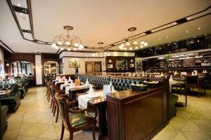 une salle à manger avec des tables, des chaises et des lustres dans l'établissement Hôtel-Restaurant L'Auberge, à Spa