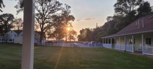 una cerca blanca frente a una casa con patio en Hideaway Country Inn, en Bucyrus