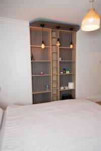 a bedroom with a white bed and a book shelf at Guest house in Wythenshawe