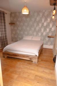 a bed in a room with a wall at Guest house in Wythenshawe