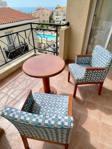 balcón con mesa y 2 sillas en Quiet cozy cool apartment with full new AC and fast Wi-Fi, en Peyia