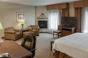 a hotel room with a bed and a fireplace at Hampton Inn & Suites Youngstown-Canfield in Canfield