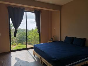 希伯萊特沙灘的住宿－CASA EBANO，一间卧室设有蓝色的床和大窗户