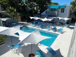 a swimming pool with umbrellas and chairs and a swimming pool at Eden House in Key West