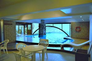 a room with a swimming pool with a table and chairs at Hosteria Patagon in Villa La Angostura