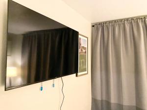 a flat screen tv hanging on a wall next to a curtain at 3 bedrooms 2 bath close to strip sleep 6 in Las Vegas