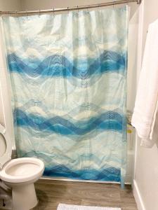 a blue shower curtain in a bathroom with a toilet at 3 bedrooms 2 bath close to strip sleep 6 in Las Vegas