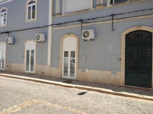 budynek z drzwiami od strony ulicy w obiekcie Penedo Grande suítes Estúdio w mieście São Bartolomeu de Messines