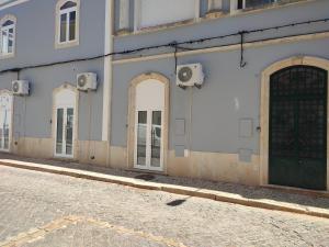 a building with doors on the side of a street at Penedo Grande suítes Estúdio in São Bartolomeu de Messines