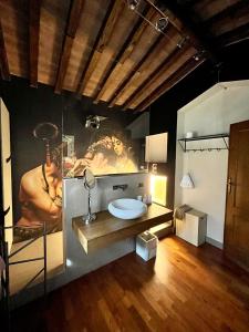 a bathroom with a sink and a large painting on the wall at Villa Daniela in Camaiore