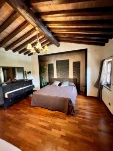 um quarto com uma cama grande e pisos em madeira em Villa Daniela em Camaiore