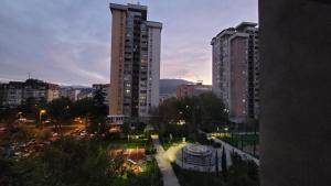 vistas a una ciudad por la noche con edificios altos en Soleil Central Apartments, en Skopje