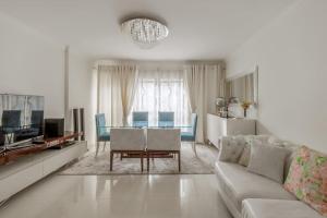 a white living room with a couch and a table at Maison Soleil Oeiras in Oeiras