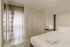 una camera da letto bianca con un letto bianco e una finestra di Maison Soleil Oeiras a Oeiras